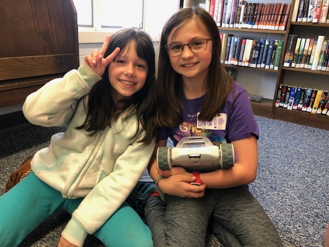 two students posing with their RVR  robot